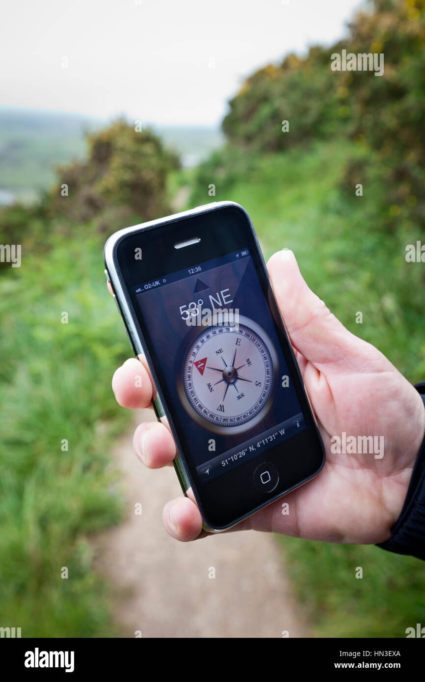 Woolacombe, Royaume-Uni - Mai 17, 2011 : main tenant un Apple iPhone 3GS exécutant l'application boussole montrant la position et Banque D'Images