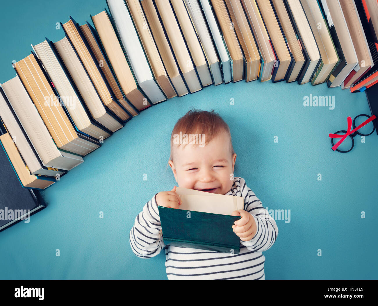 Un an bébé avec spectackles et livres Banque D'Images