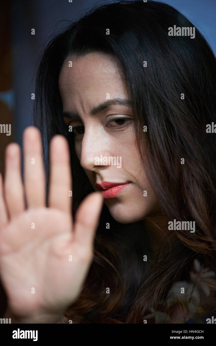 Femme triste de toucher la fenêtre en verre avec la main Banque D'Images