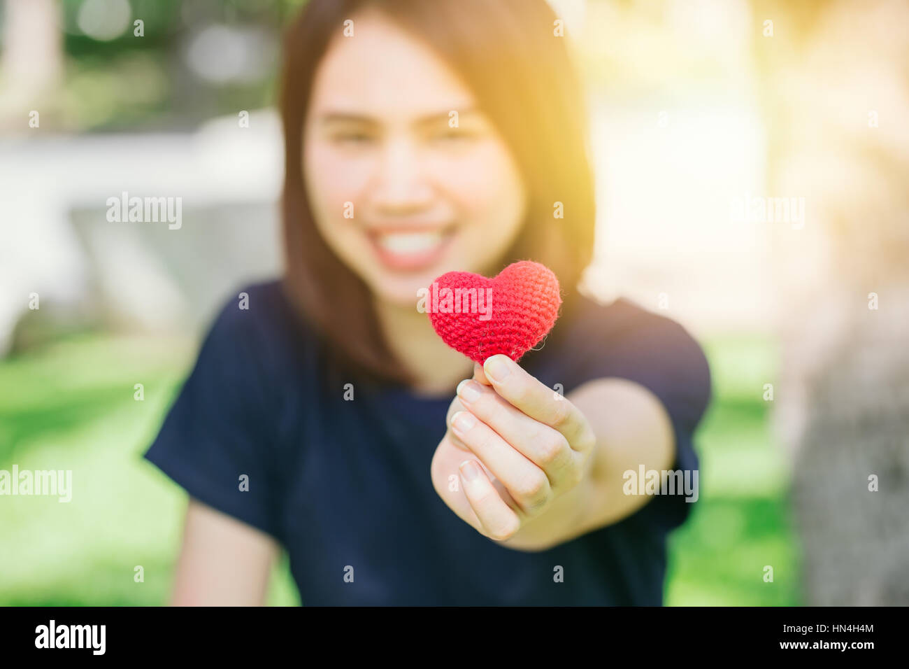 Nouvel ami aime rencontrer et sourire mignon date Thai asiatique teen main courante red heart sweet loving symbole de prendre soin ou de charité pour aider à vous. Banque D'Images