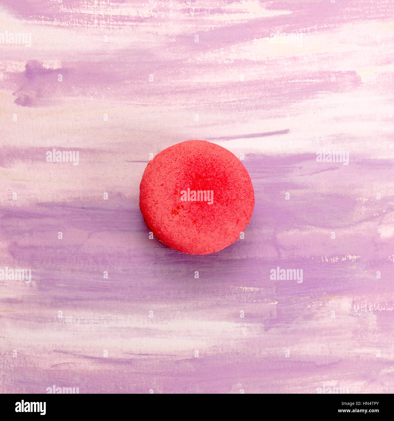 Une photo d'un macaron, tourné à partir de ci-dessus sur une texture aquarelle violet et blanc, avec copie espace Banque D'Images