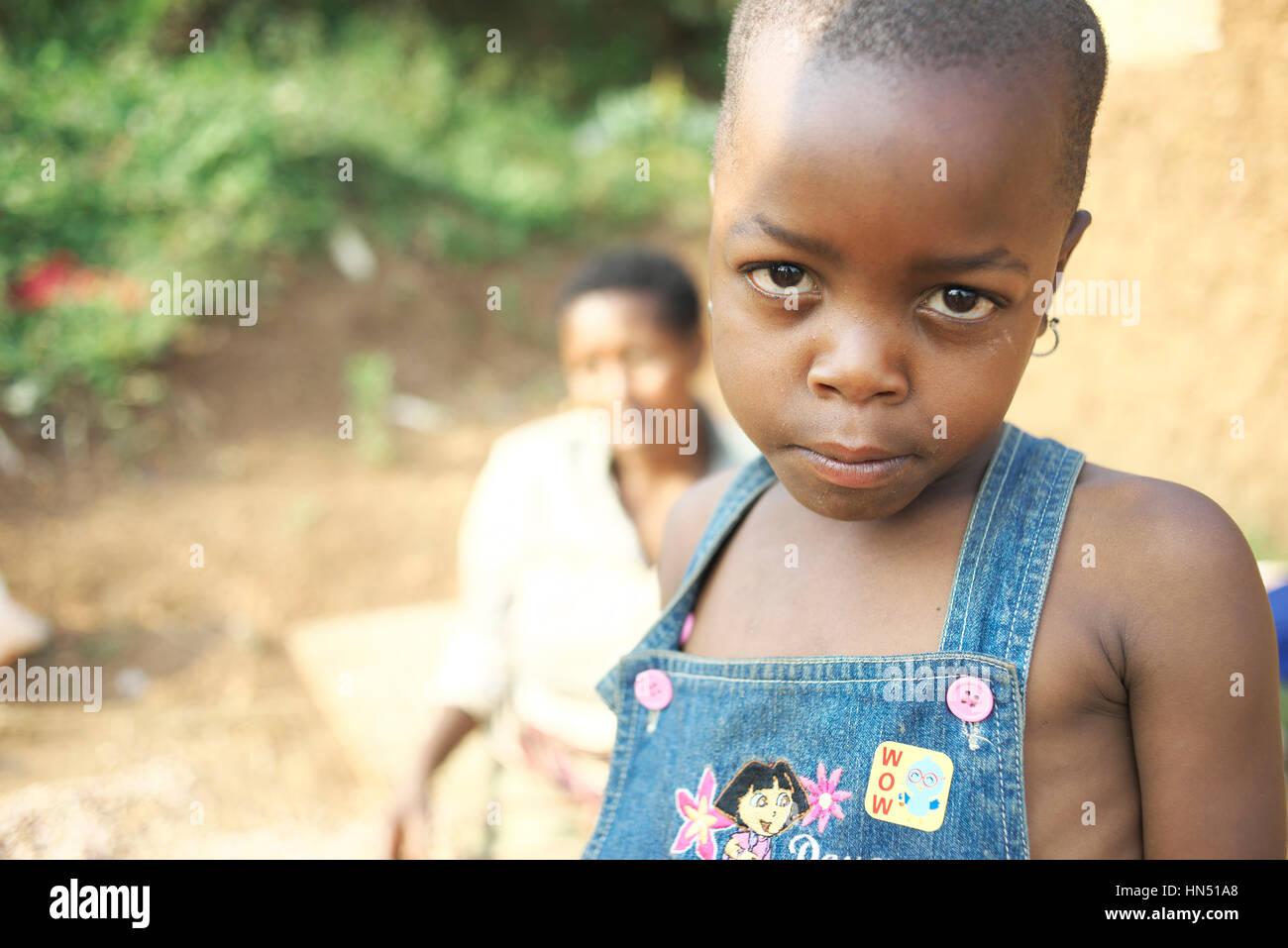 Les jeunes enfants ougandais à la maison dans les régions rurales de l'Afrique de l'Est regarde l'appareil photo Banque D'Images
