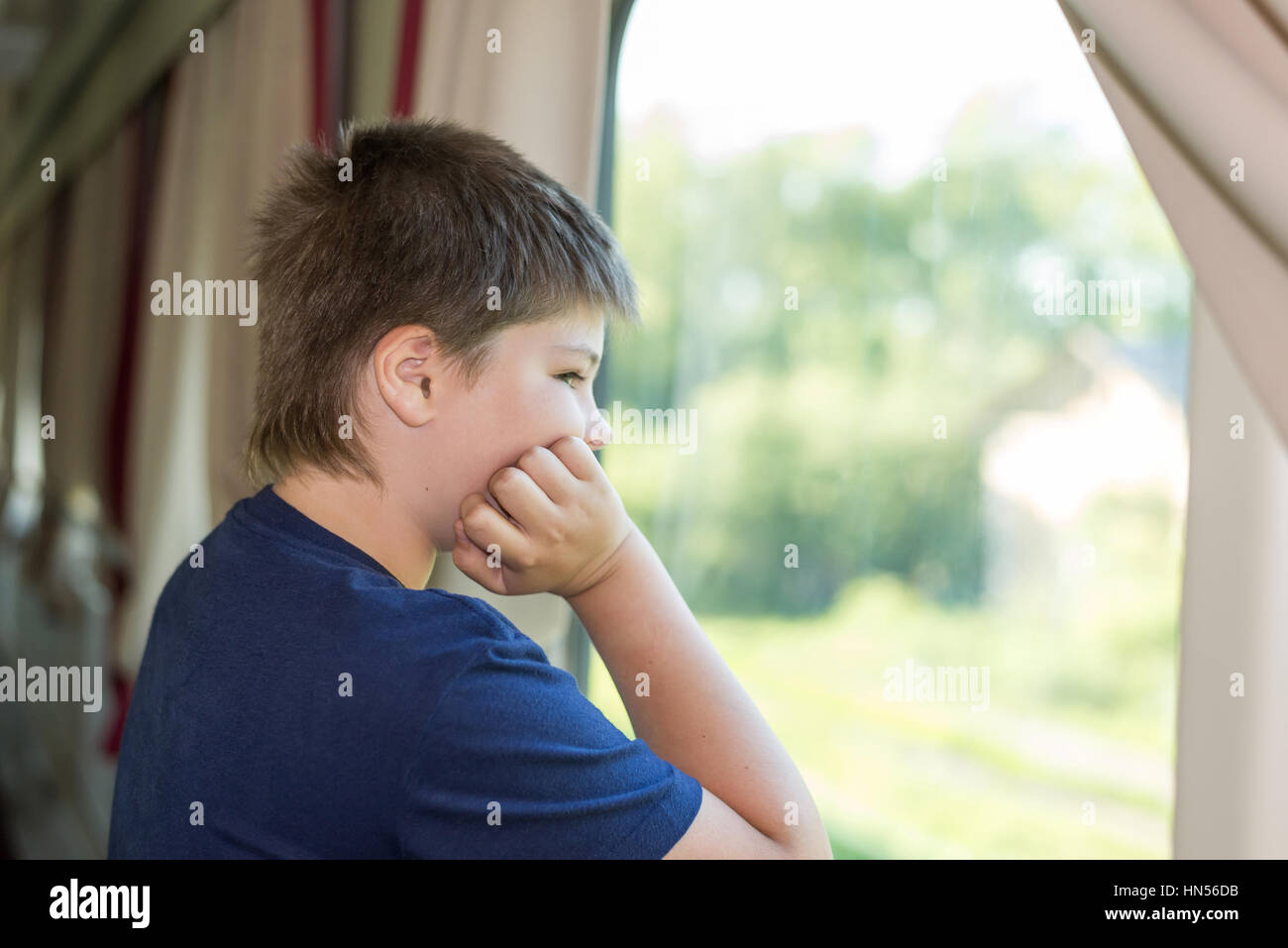 Le garçon regarde par la fenêtre sur le train Banque D'Images