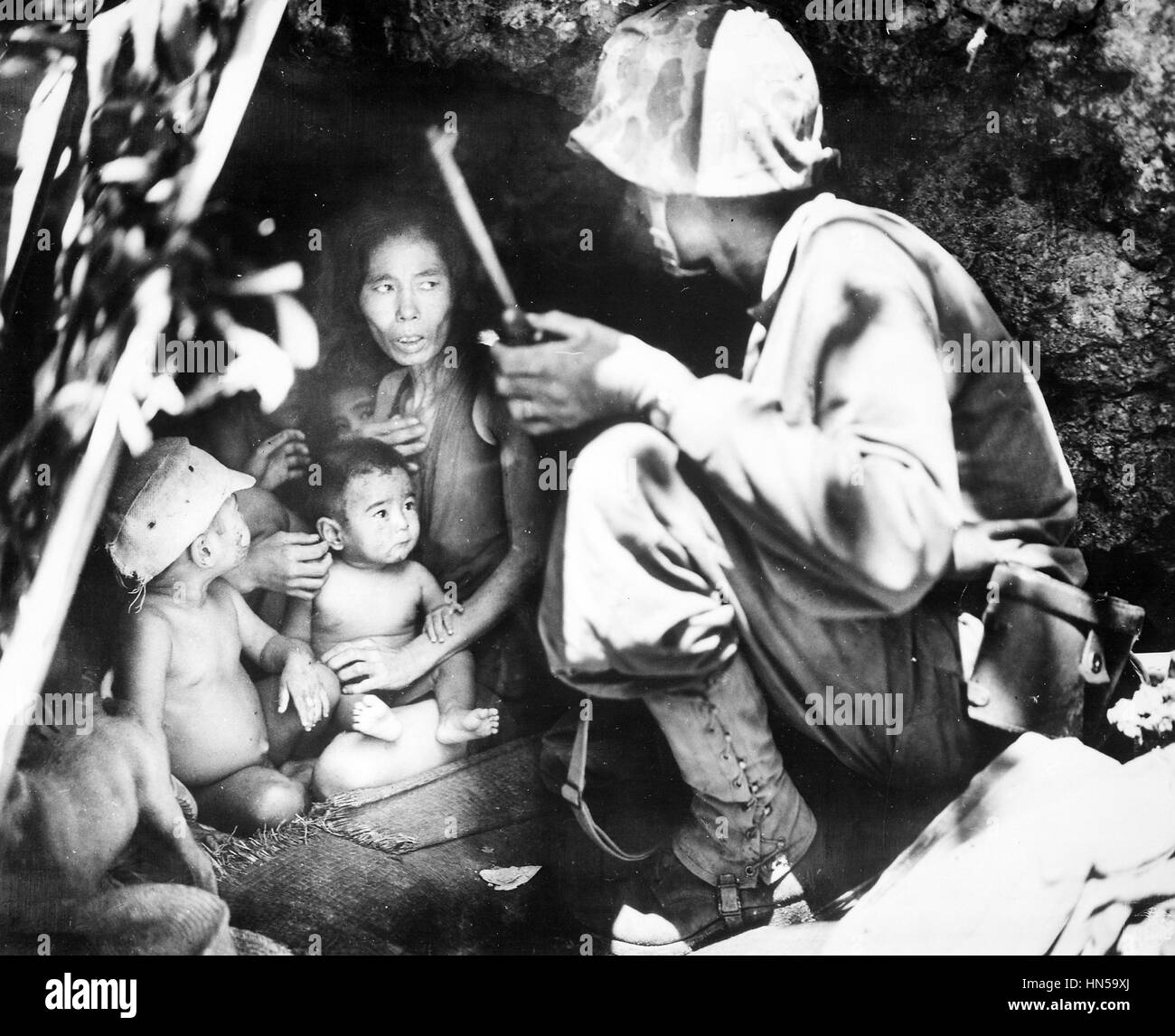 La guerre du Pacifique pendant la bataille de Saipan un Marine américain trouve une famille se cache dans une grotte à flanc de colline, le 21 juin 1944. Photo : Corp Angus Robertson/Marines américains Banque D'Images
