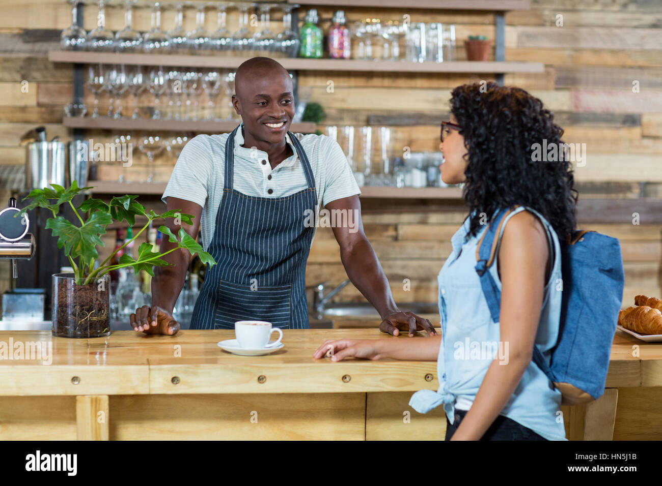 Femme en interaction avec serveur au comptoir dans cafÃƒÂ© Photo Stock -  Alamy