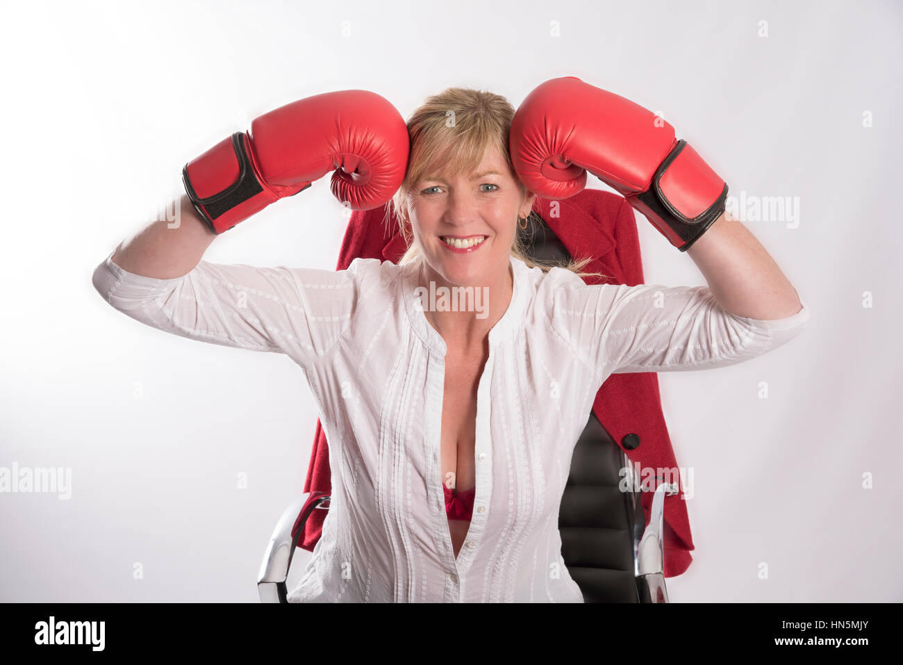 Femme office worker wearing red boxing gloves assis sur une chaise Banque D'Images