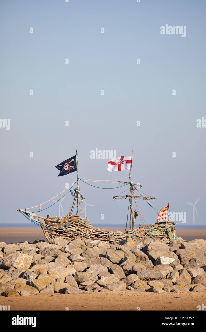 Lever du soleil à nouveau Hoylake Plage avec une aire de jeux en bois flotté bateau pirates à Wallasey, Merseyside, Wirral, England, UK. Banque D'Images