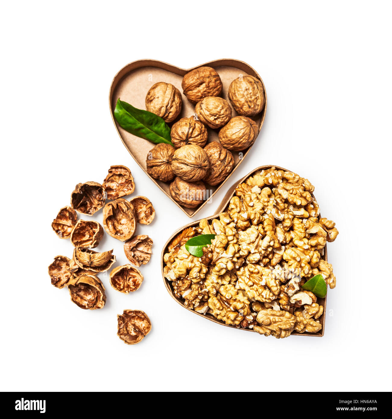 Les cerneaux de noix dans la boîte en forme de coeur, l'ensemble des noix et coquilles de l'alimentation santé et la médecine alternative concept, isolé des objets Banque D'Images