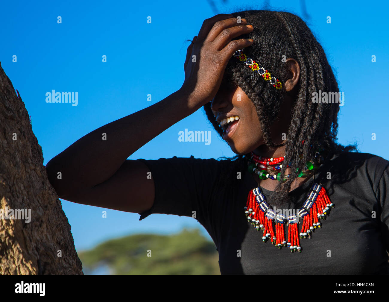 Portrait d'une tribu Afar fille aux cheveux tressés en riant, région Afar, Ethiopie, Chifra Banque D'Images