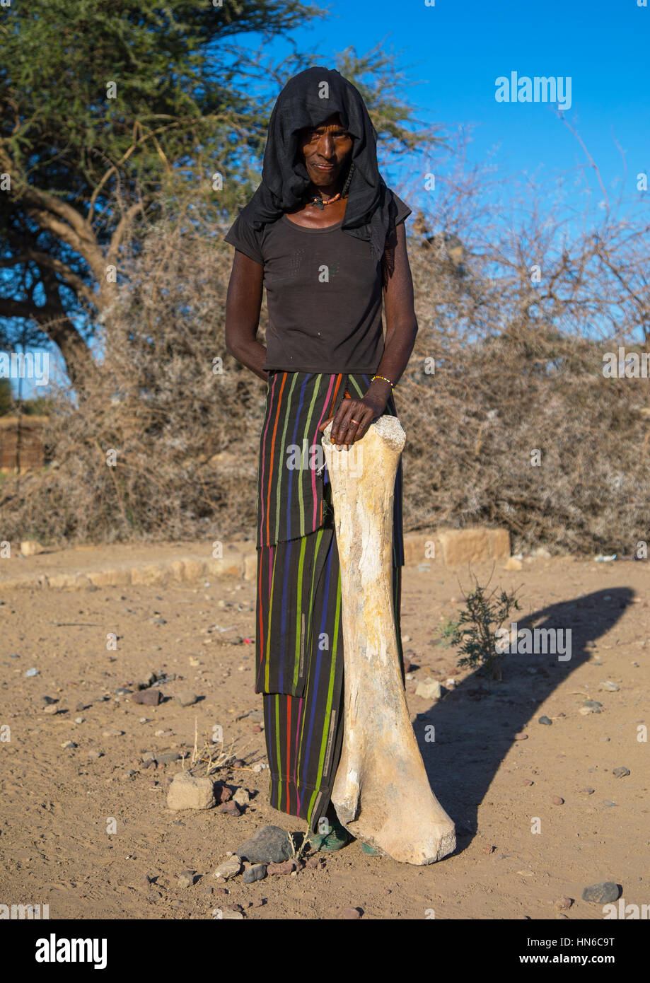 Afar tribe femme avec un fémur d'éléphants trouvés dans une rivière à sec, région Afar, Ethiopie, Chifra Banque D'Images