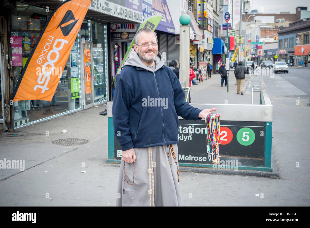 Un prêtre franciscain distribue gratuitement des chapelets dans le le moyeu, dans la section de la Melrose New York borough du Bronx le Dimanche, Février 5, 2017. Le moyeu Central Business District tient son nom de la convergence de quatre routes, à l'est la 149e Rue, Willis, Melrose et troisième avenues et est le plus ancien des grands quartiers commerçants de l'arrondissement. (© Richard B. Levine) Banque D'Images