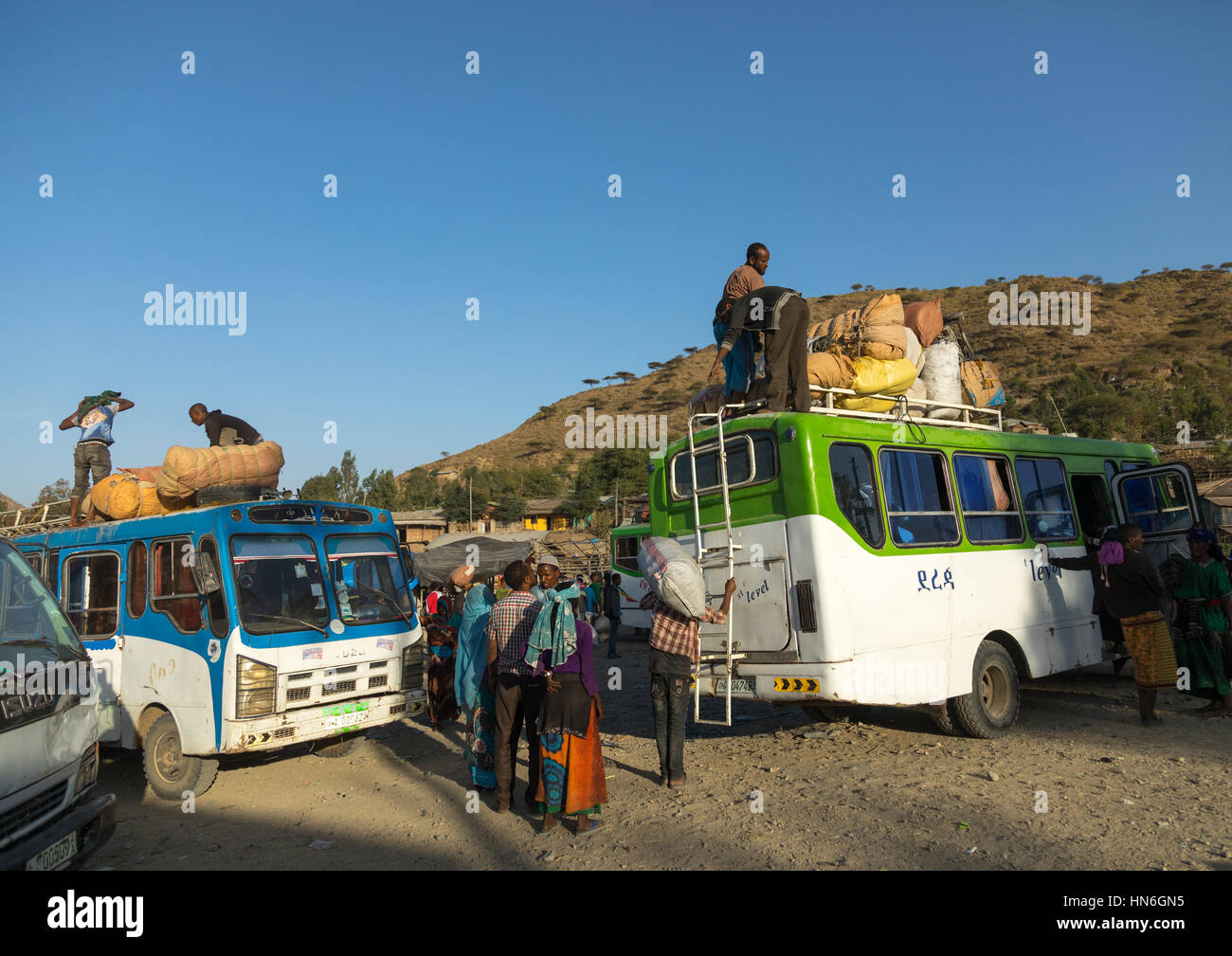 Les gens des bus avec les sacs de chargement à la fin du marché, région d'Amhara, Senbete, Ethiopie Banque D'Images