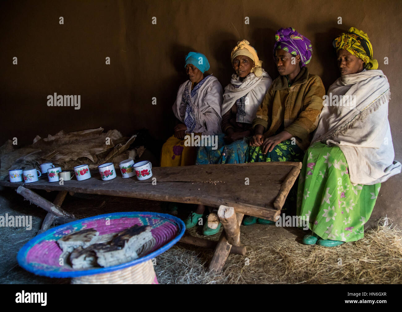 Les femmes éthiopiennes de la région des Highlands dans une maison à partager un verre et manger du pain, région d'Amhara, Debre Birhan, Ethiopie Banque D'Images