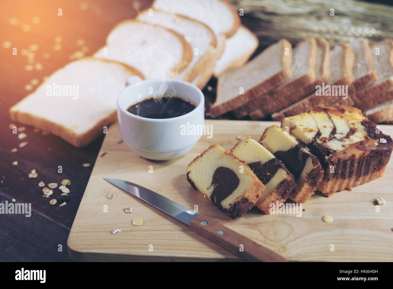 Tranches de gâteau de beurre et de café chaud sur la table de bois mou du soleil. évasé. Banque D'Images
