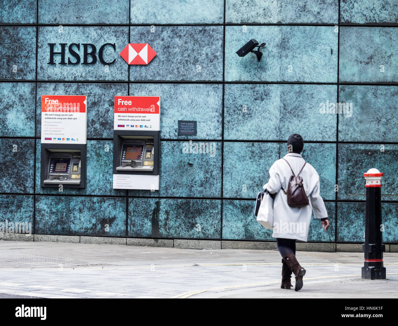 Des distributeurs automatiques de billets HSBC Londres - une femme marche vers les distributeurs HSBC dans le centre de Londres avec les caméras de surveillance de la DAB. Banque D'Images