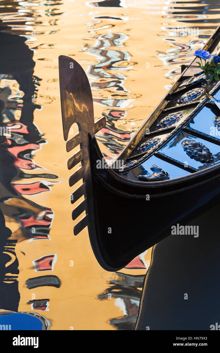 Gondola détail dans la lumière du soleil d'Or avec reflets du bâtiment dans l'eau à Venise, Italie en janvier Banque D'Images