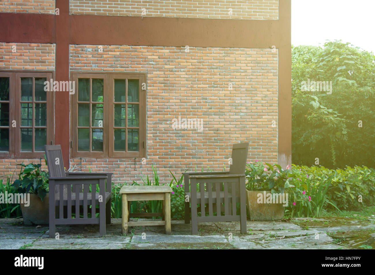 Table et chaise d'extérieur en brique accueil avant dans le jardin. Flare Soft du soleil. Banque D'Images