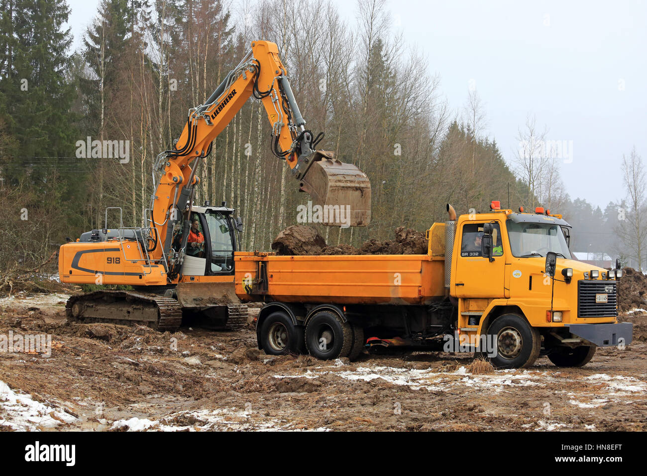 FORSSA, FINLANDE - le 28 janvier 2017 : pelle sur chenilles Liebherr R 918 sol charges sur Sisu jaune SR 332 chariot bascule en hiver. Banque D'Images