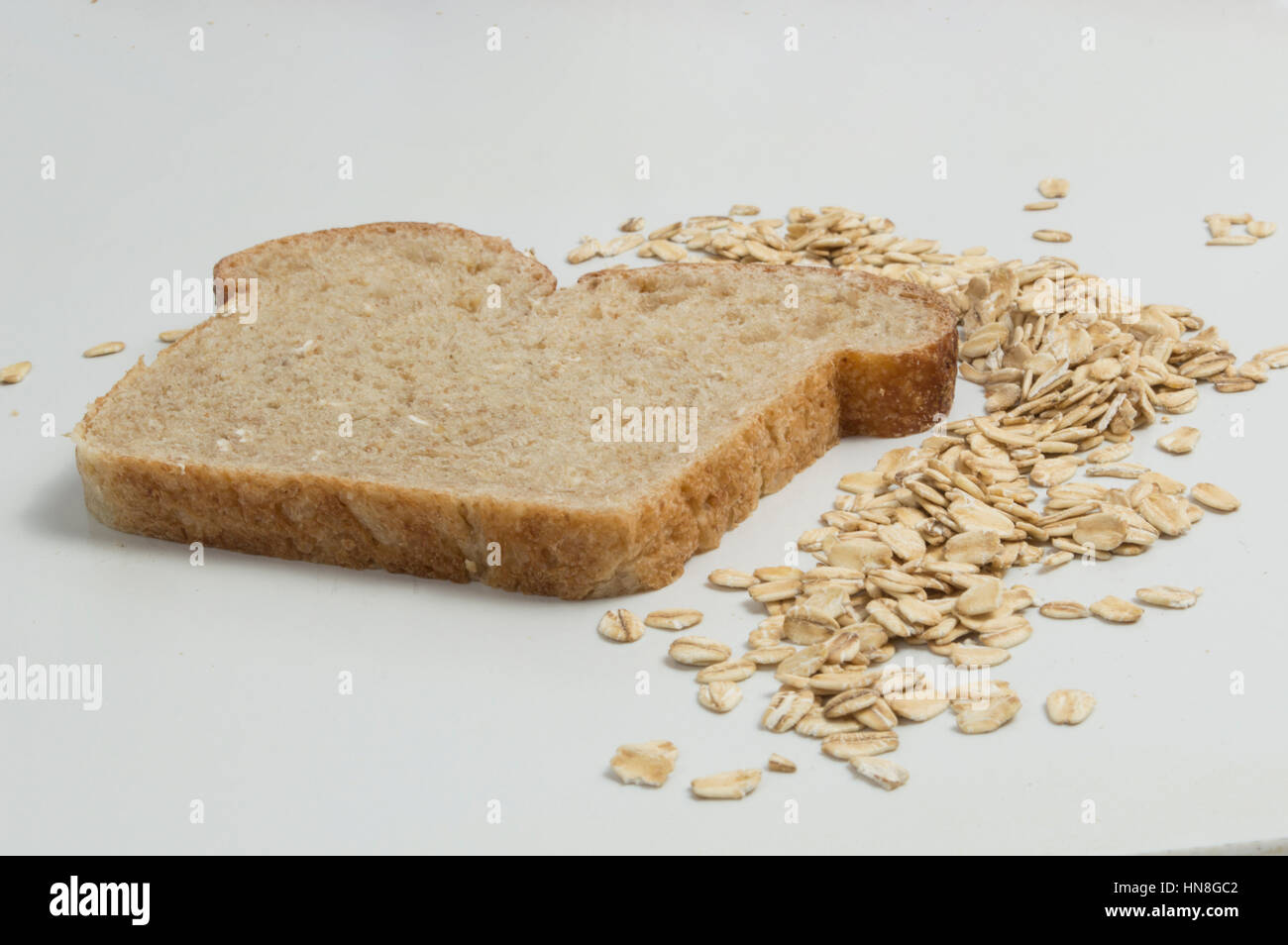 Tranche de pain de blé entier avec de l'avoine sur fond blanc Banque D'Images