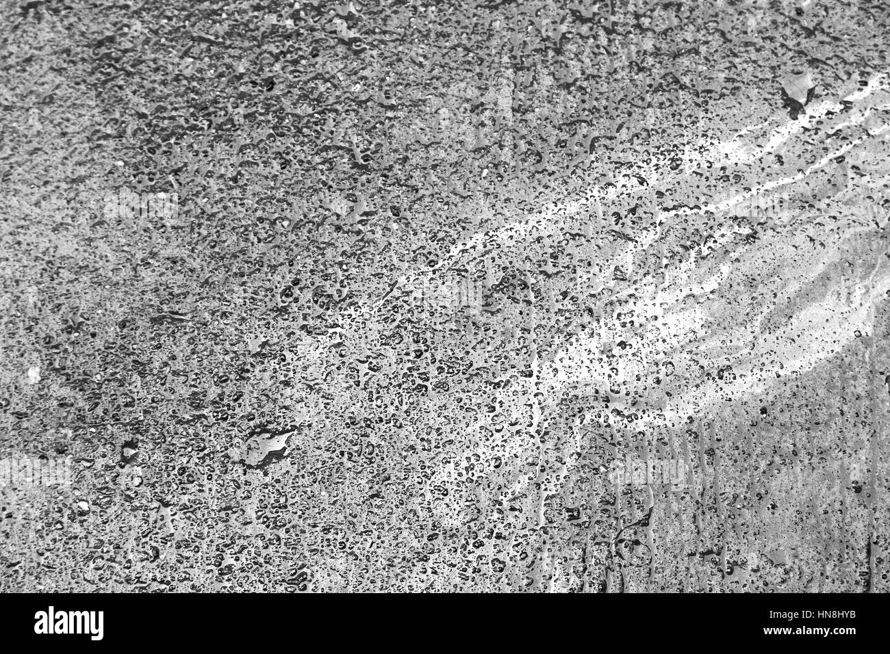 Après la pluie dans le trottoir couleur arc-en-ciel comme faire de l'essence Banque D'Images