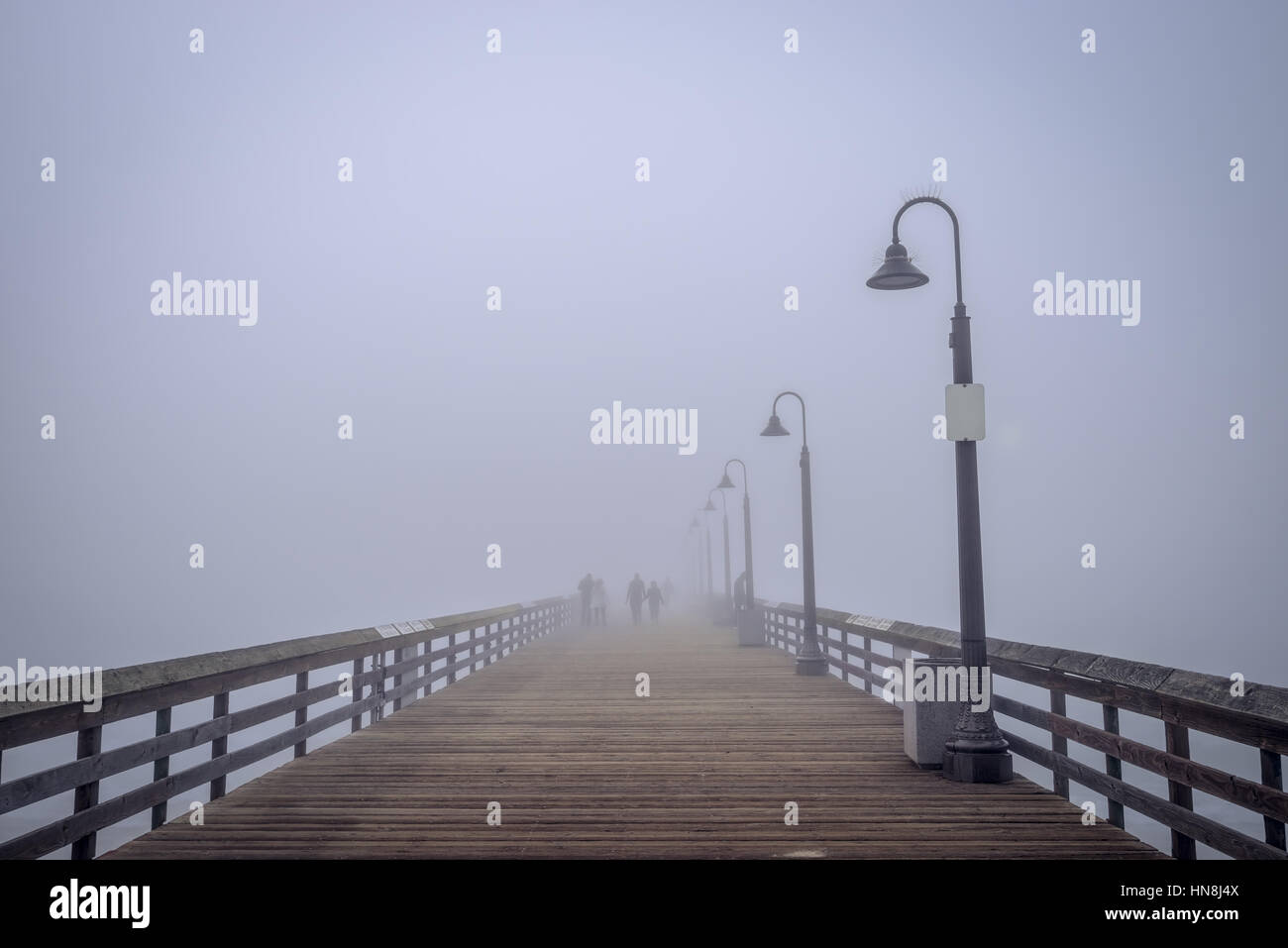 Silhouettes de personnes dans le brouillard sur l'Imperial Beach Pier. Banque D'Images