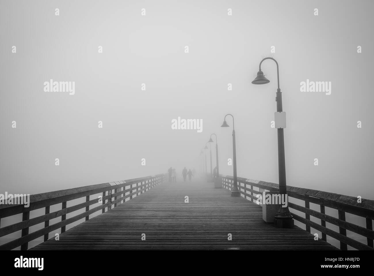 Silhouettes de personnes dans le brouillard sur l'Imperial Beach Pier. Banque D'Images