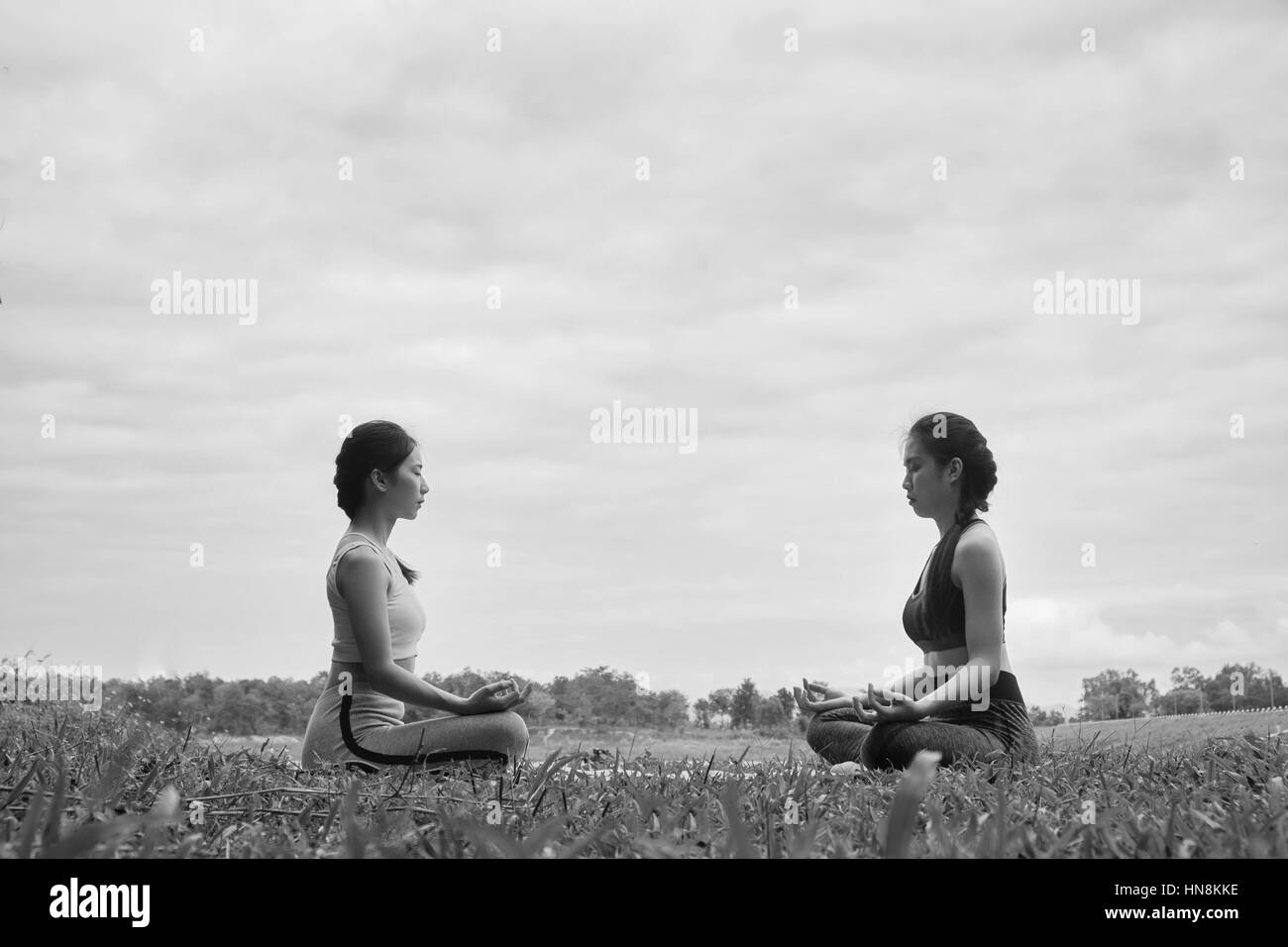 Deux jeune fille faisant du yoga fitness piscine dans un beau paysage montagneux. Banque D'Images