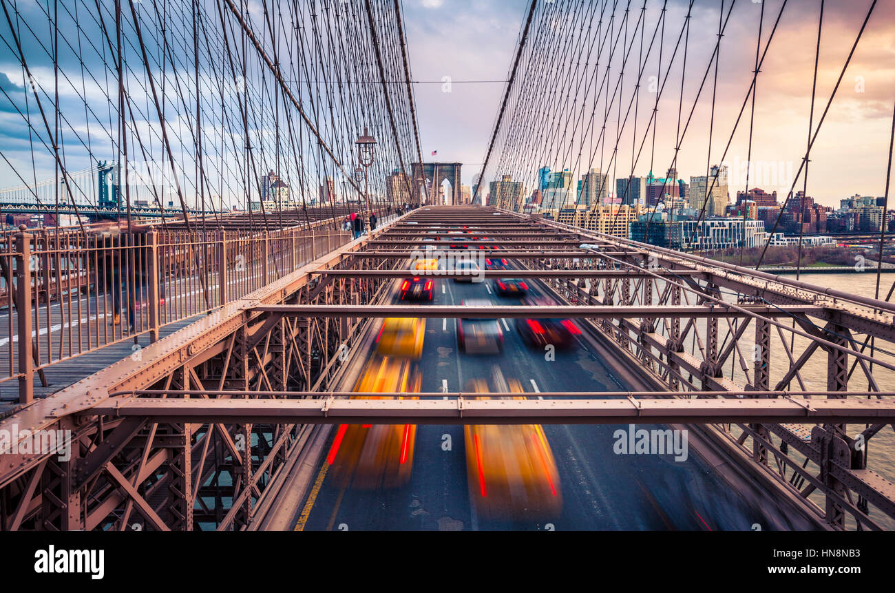 La circulation le Bridgeat nuageux coucher de Brooklyn à New York City Banque D'Images