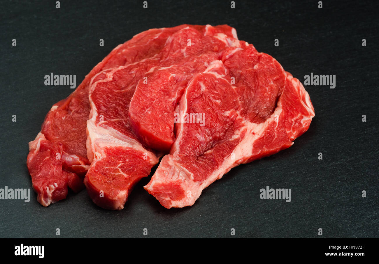 Produits frais et de la viande crue. le boeuf cru prêt à cuire. Tableau noir en arrière-plan Banque D'Images