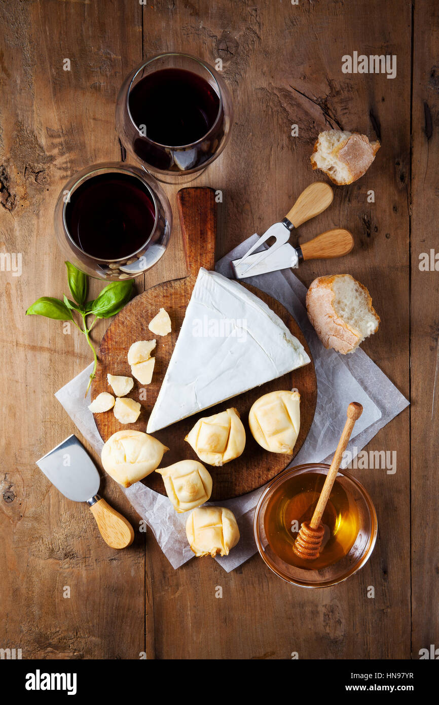 Plateau de fromages assortiment de différents types de fromages et de miel sur planche à découper en bois Banque D'Images