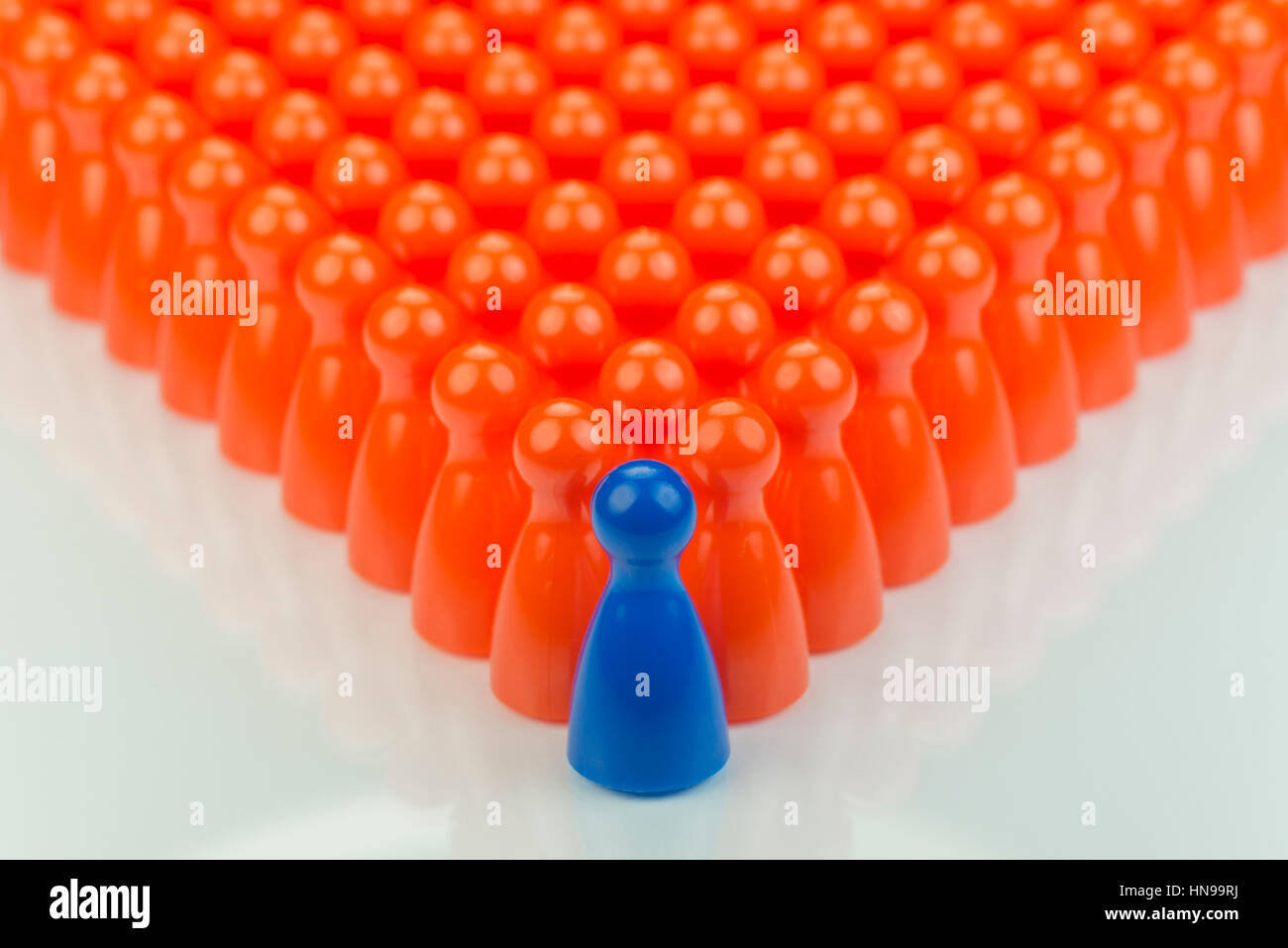 Pions et jeu orange conceptuel un pion bleu jouer comme abstraite afficher d'inégalité dans la couleur et le nombre de Banque D'Images
