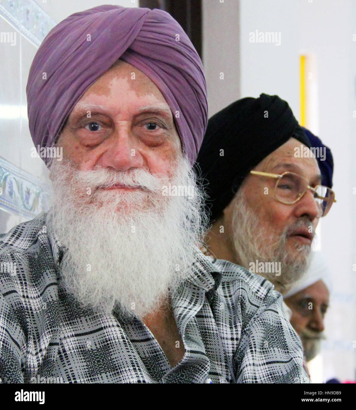 Un Sikh indien âgé avec une longue barbe blanche portant un turban avec le trouble de la peau du vitiligo lors d'un mariage sikh en Malaisie Banque D'Images