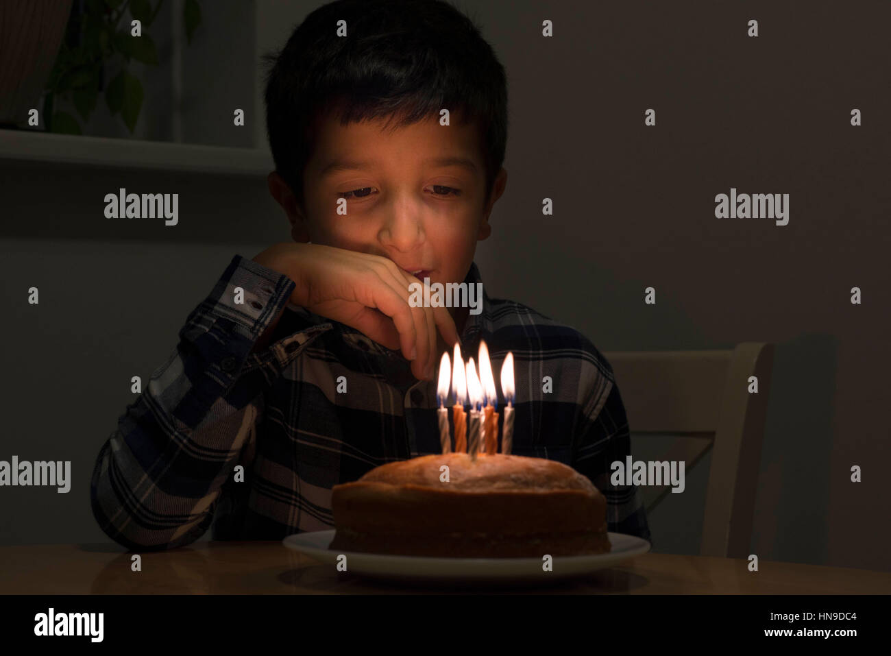 Boy looking at birthday cake Banque D'Images