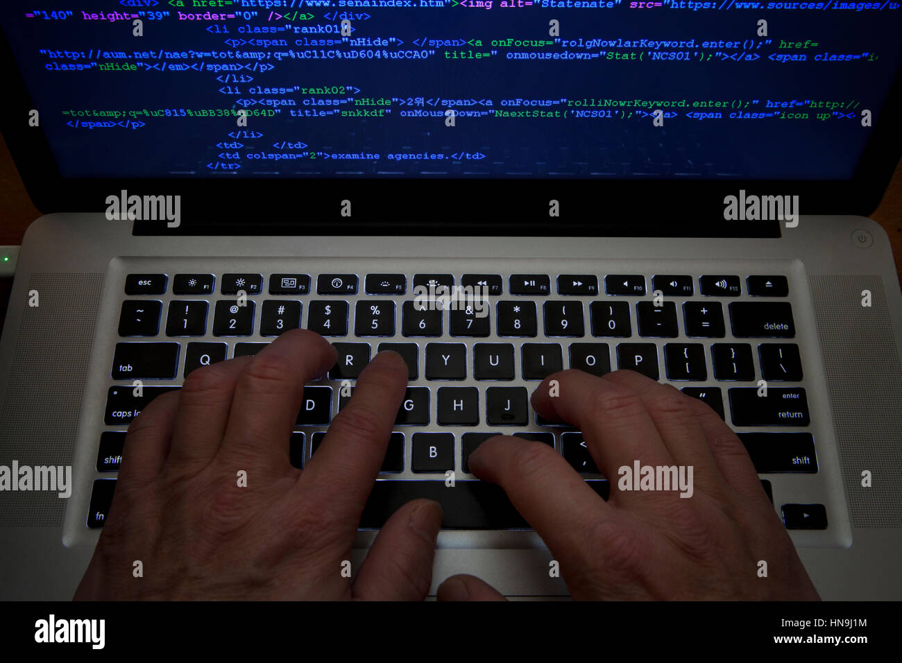 Code Man typing on laptop computer Banque D'Images