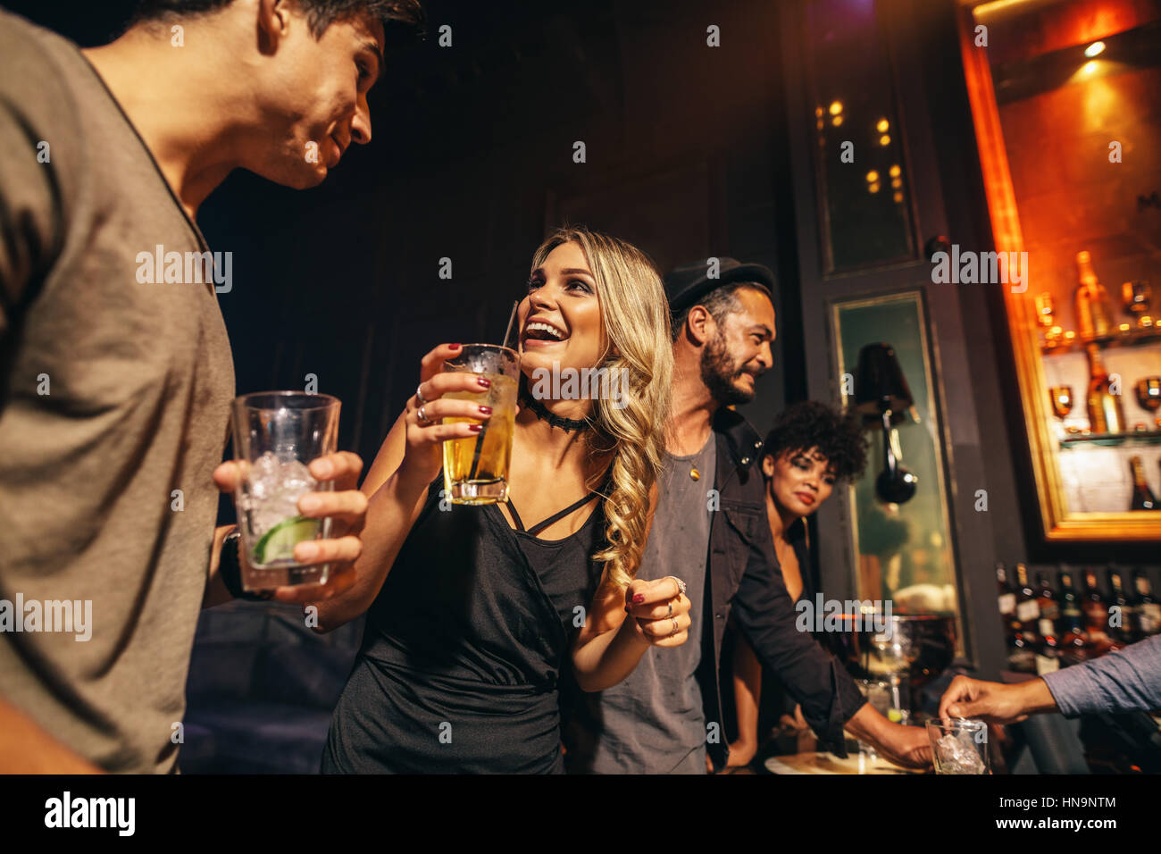 Groupe de jeunes s'amusant à la discothèque. Jeunes amis bénéficiant d'une nuit au bar. Banque D'Images