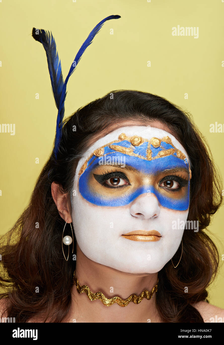 Les femmes avec masque d'or body art sur fond jaune Banque D'Images