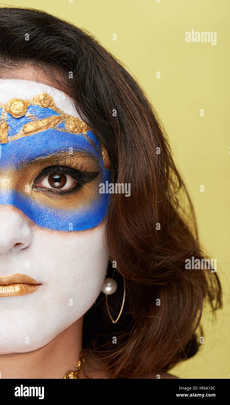 Près de la moitié des femmes font face à masque d'or avec un miroir Banque D'Images