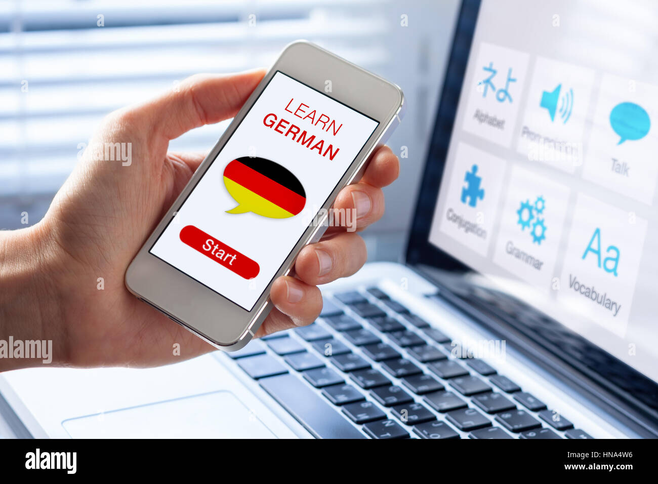 Apprendre l'allemand en ligne avec un concept de langue personne montrant l'e-learning application sur téléphone mobile avec le pavillon de l'Allemagne Banque D'Images