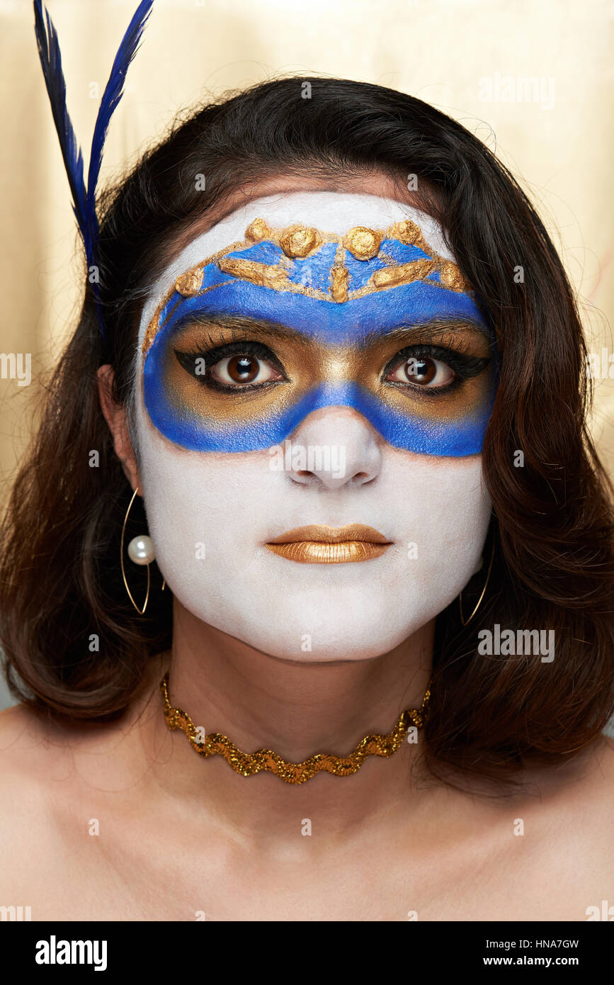 Visage de femme peint avec masque sur fond doré Banque D'Images