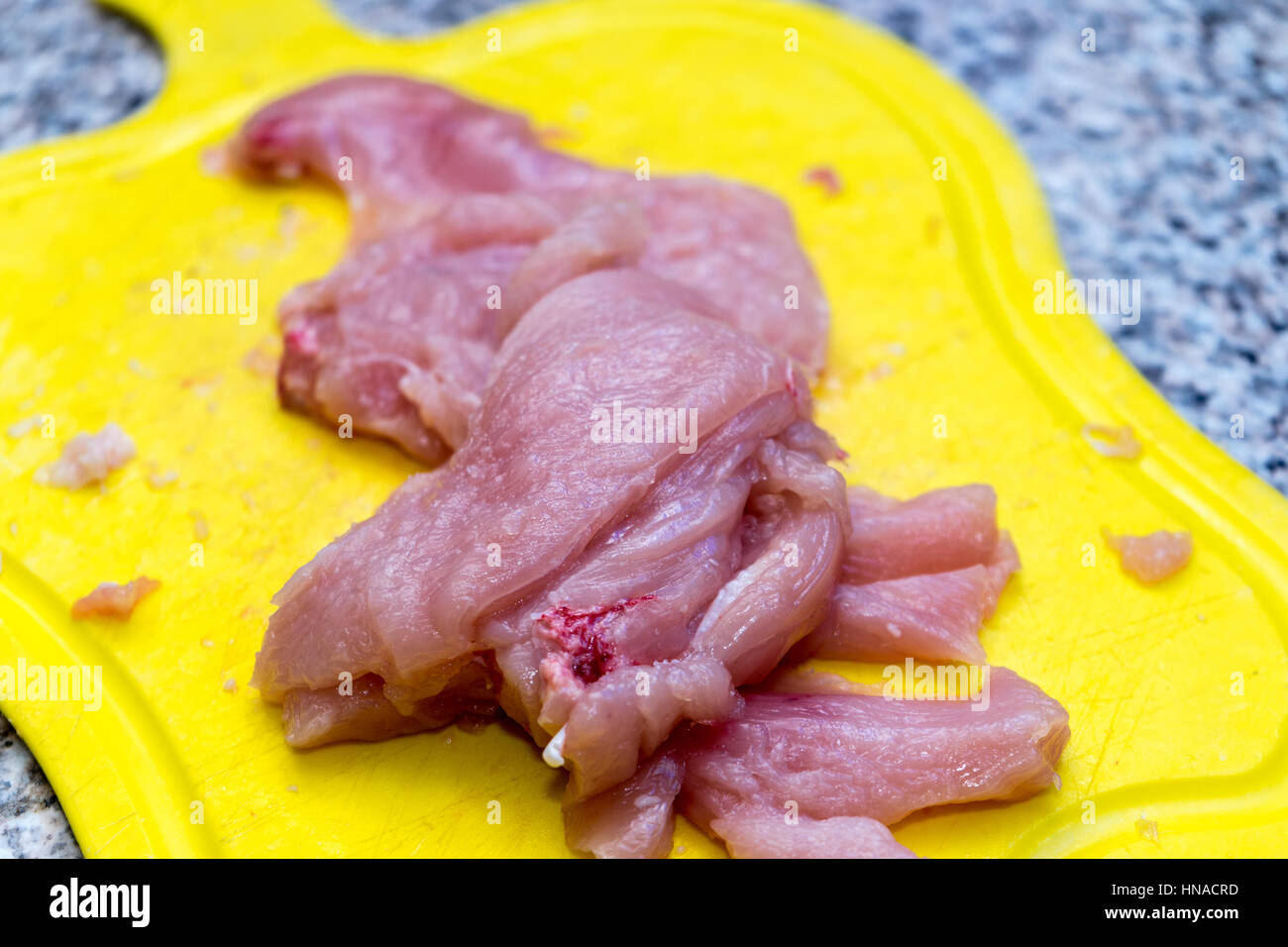 Matières filet de poulet sur une planche à découper Banque D'Images