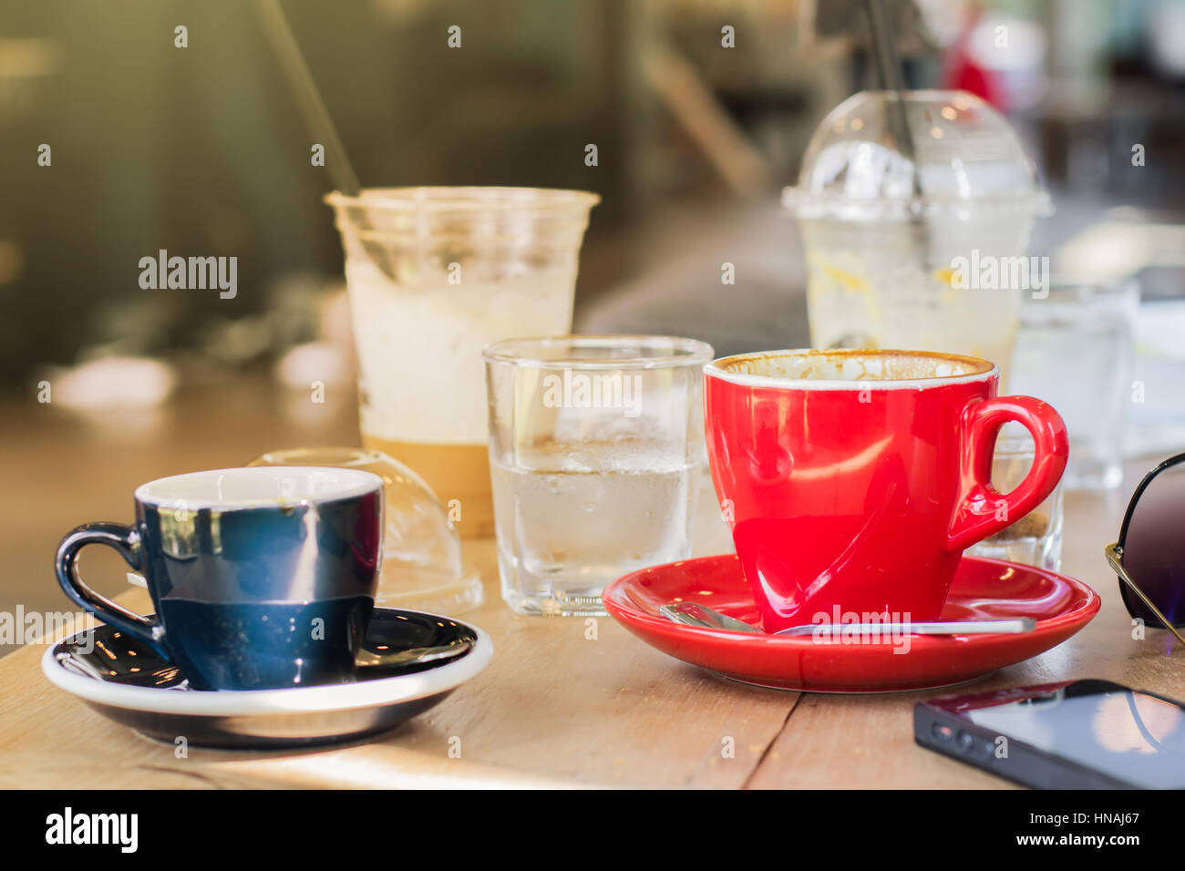 Tasse de café rouge avec smart phone on wooden table Banque D'Images