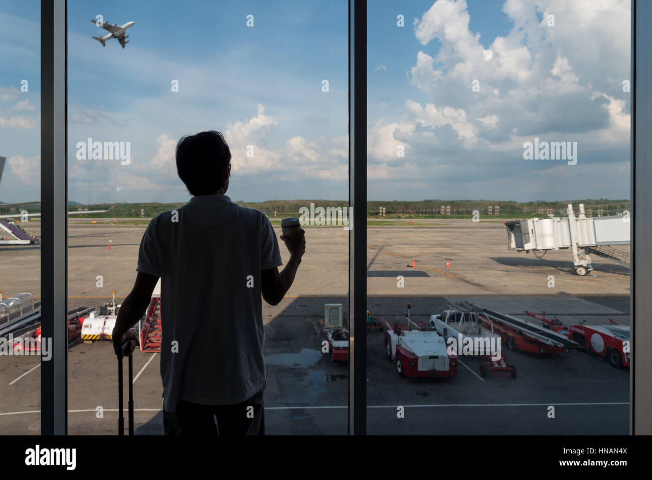 La face arrière de la meilleur garçon en termainal à l'aéroport à la recherche de l'avion en vol au-dessus de l'aéroport, et voyage vie vacances concept Banque D'Images