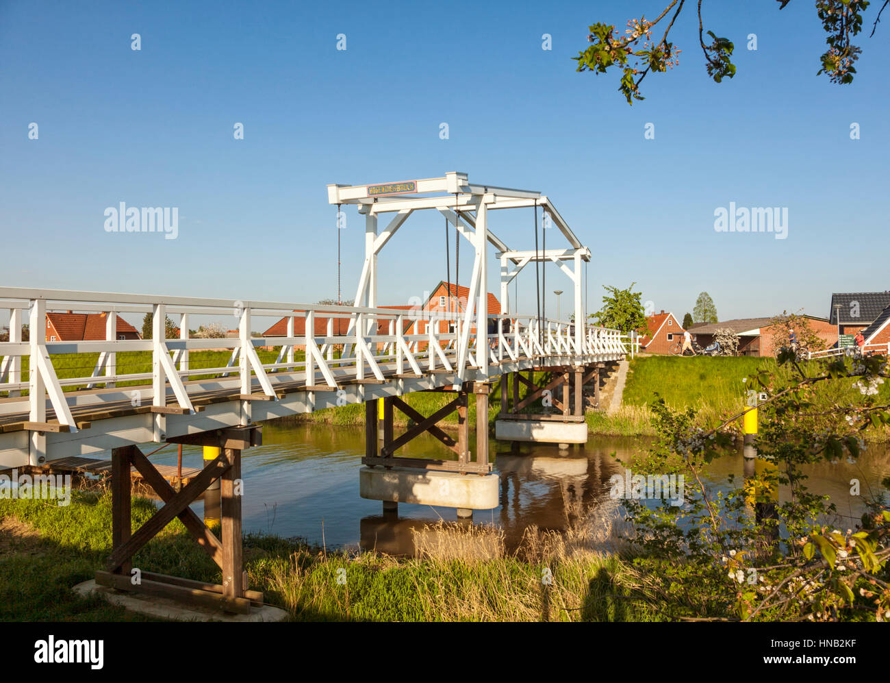 Steinkirchen, Allemagne - le 8 mai 2016 : pont-levis en bois à travers Lühe river dans la région de l'Altes Land de Basse-Saxe dans la lumière du soir, les touristes avec le vélo Banque D'Images
