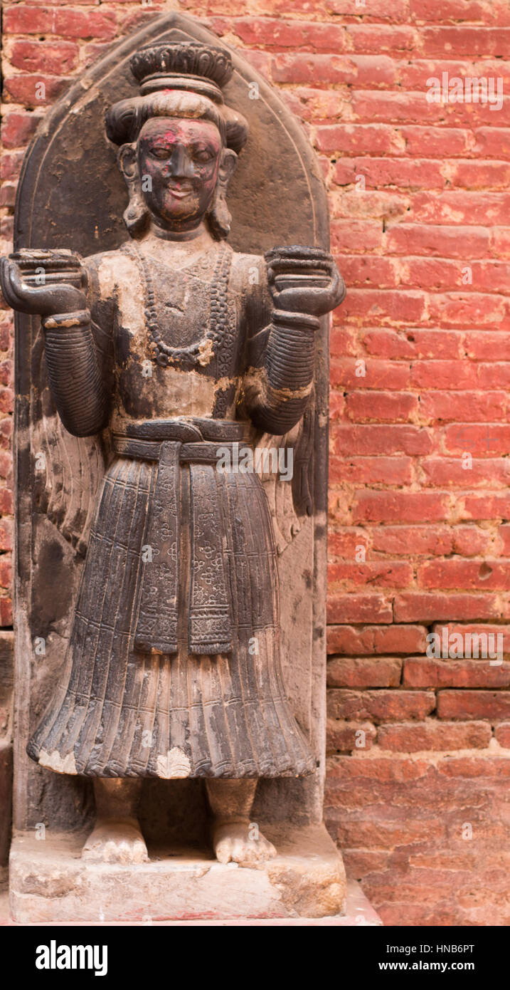 Statue en bois de gardien devant un bâtiment à Bhaktapur, Katmandou, habillée dans le style traditionnel népalais Banque D'Images
