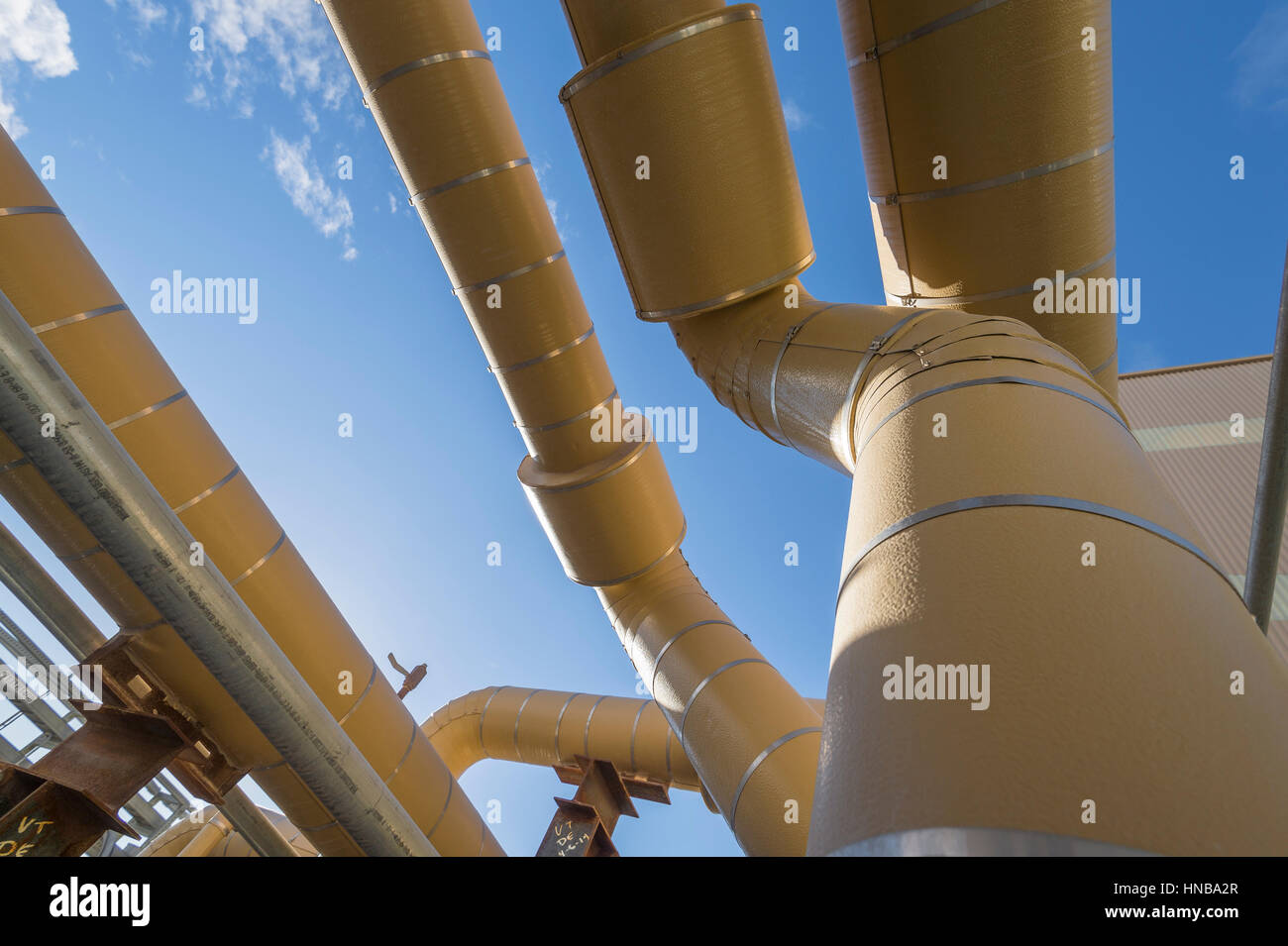 Tuyaux industriels jaune avec ciel bleu Banque D'Images