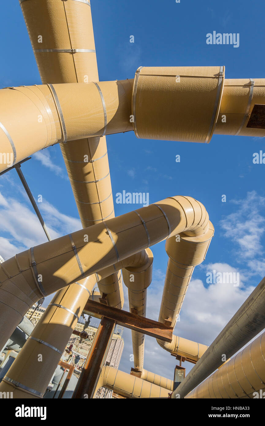 Tuyaux industriels jaune avec ciel bleu Banque D'Images