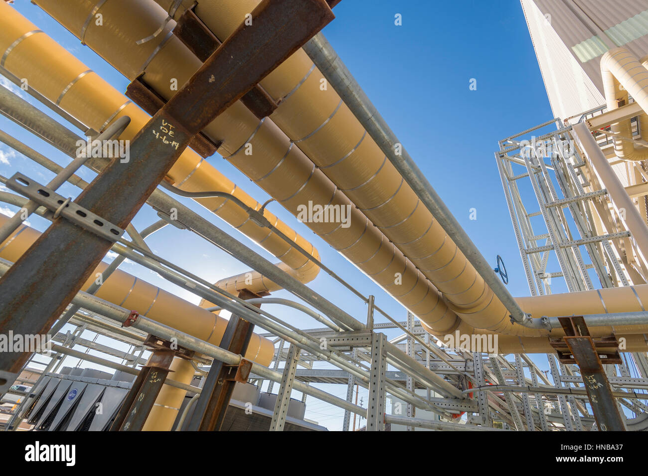 Tuyaux industriels jaune avec ciel bleu Banque D'Images
