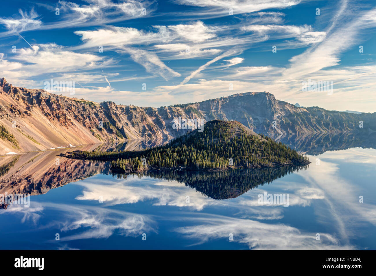 Un parfait reflet de l'île de l'Assistant avec des nuages dans le lac du cratère, juste après le lever du soleil. Crater Lake National Park, Oregon. Banque D'Images