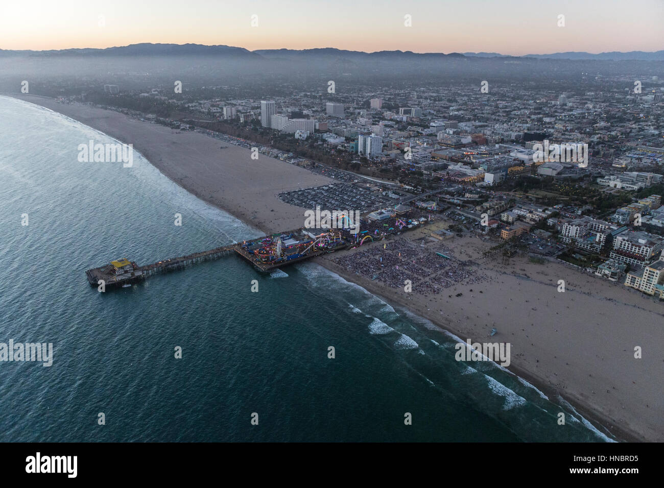 Santa Monica, Californie, USA - 21 juillet 2016 : Après le coucher du soleil crépuscule vue aérienne de grande foule rassemblée à la jetée de Santa Monica, près de Los Angeles. Banque D'Images