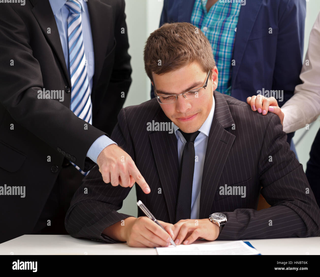 Confident businessman la signature du contrat en face de son équipe Banque D'Images